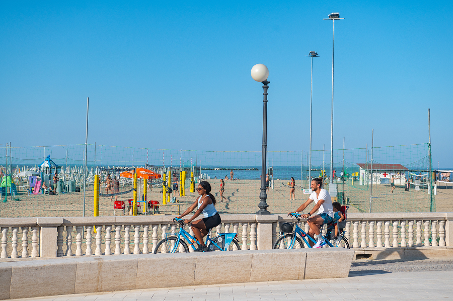 Famiglia in vacanza con bici a noleggio sul lungomare di Cesenatico.